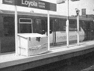 L trains passing through Loyola station in an urban setting