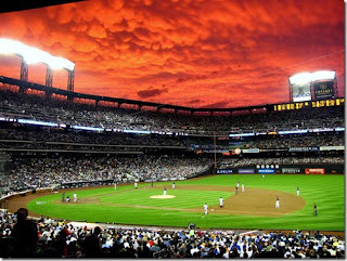 Father and sons playing baseball on a green diamond