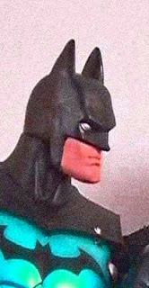 Two Batman action figures held by a child